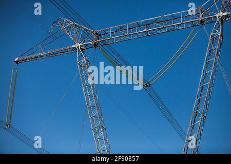 Pylône électrique (poteau) avec isolants en verre sur fond ciel bleu clair. Photo en gros plan. Banque D'Images