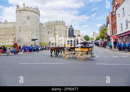 Une excursion touristique à cheval et en voiture s'approche du château de Windsor et La statue de la reine Victoria à Castle Hill à Windsor centre ville par une journée ensoleillée Banque D'Images