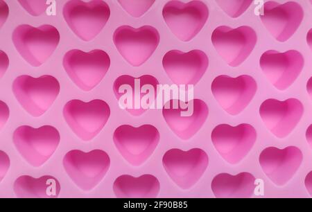 Moule de confiserie à base de silicone en forme de petits coeurs roses gros plan. Banque D'Images