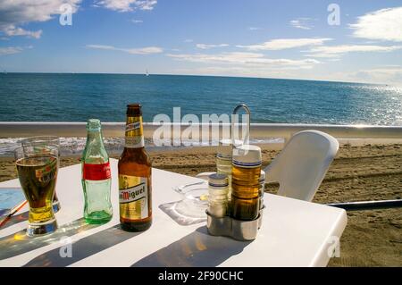 Authentique, table au hasard sur le restaurant en front de mer de Fuengirola, Espagne, avec vue sur la Méditerranée. Bouteille de bière et verre San Miguel Banque D'Images