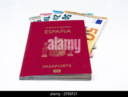 Passeport de voyage espagnol avec quelques billets en euros isolés sur fond blanc. Union européenne et monnaie unique. Voyage et argent Banque D'Images