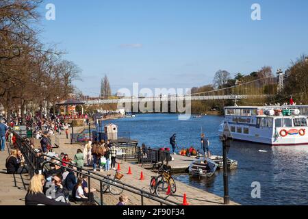 Bateau sur la rivière Dee à Chester Cheshire avec touristes vacanciers vacanciers randonneurs de jour appréciant le soleil assis la rive de la rivière Banque D'Images