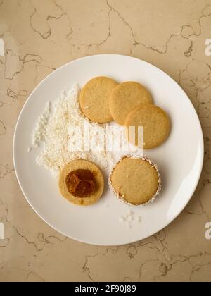 Biscuits ronds avec Dulce de leche et noix de coco râpée plaque blanche Banque D'Images