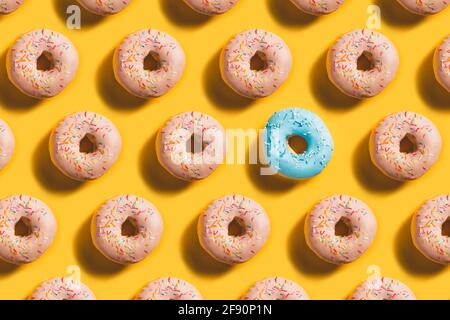 Motif en forme de beignet avec un accent bleu sur fond jaune Banque D'Images