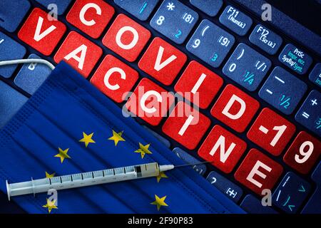 Immunisation COVID-19 dans l'Union européenne avec seringue et masque facial avec drapeau de l'UE et message de vaccination sur clavier d'ordinateur. Concept de Covid vaccinat Banque D'Images