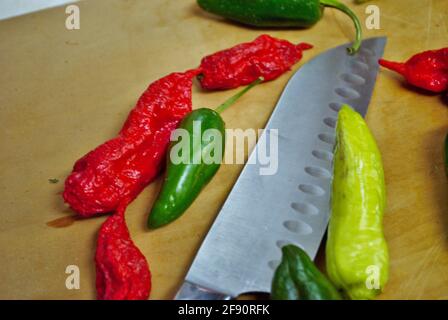Poivre de banane jalapeno habanero frais et couteau sur un bois planche à découper Banque D'Images