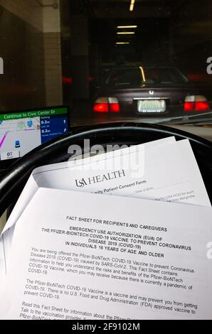 Un patient lit un formulaire de consentement en attendant d'entrer dans une clinique de vaccination COVID-19 au centre civique mobile de Mobile, Alabama. Banque D'Images