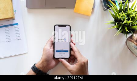 CHIANG MAI, THAÏLANDE, APR 15, 2021 : UN homme tient Apple iPhone X avec application LinkedIn sur l'écran.LinkedIn est une application de partage de photos pour Banque D'Images
