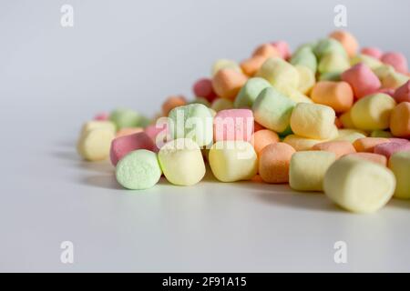 Des marshmallows colorés offrent un arrière-plan blanc avec espace de copie. Vue de dessus Banque D'Images