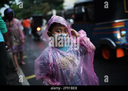 Jakarta, DKI Jakarta, Indonésie. 15 avril 2021. Les résidents font la queue en appliquant la règle de distance teh pour obtenir le takjil gratuit sur les routes du centre de Jakarta, jeudi (04/15/2021). Les résidents sont tenus de faire la queue en appliquant une distance de deux mètres pour prévenir la propagation du coronavirus. EEveryday le comité fournit gratuitement 400-600 paquets takjil qui sont des dons de résidents et des entreprises de la région. Crédit : Muhammad Zaenuddin/ZUMA Wire/Alay Live News Banque D'Images