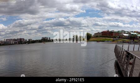 Vue panoramique depuis les berges du lac de Kaban inférieur. Catamarans colorés sous forme de voitures flottent sur l'eau. Pêcheur solitaire en ville sur le front de mer. Kazan, Banque D'Images