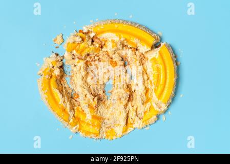 Étaler avec un gâteau à l'orange fouetté directement sur la table bleue. Délicieux gâteau détruit. Banque D'Images