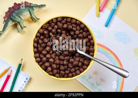 Haut de la page Voir les cornflakes de chocolat dans un bol sur le fond du dessin des enfants et des jouets. Banque D'Images