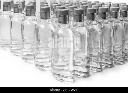 Flacons d'alcool pur non étiquetés. Une multitude de bouteilles de boissons alcoolisées maison isolées sur blanc. Production de petites liqueurs basée sur la distillation. B Banque D'Images