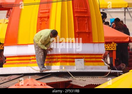 HARIDWAR, UTTARAKHAND, INDE - FÉVRIER 2021 : Un peintre colorant le bâtiment du Temple de couleur jaune et orange pendant la mela Kumbh. Banque D'Images