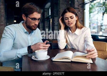 les collègues de travail dans un café s'assoient à la table du petit déjeuner communication Banque D'Images
