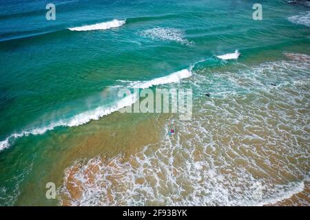 Surfeurs nageant dans l'eau à la plage d'Austinmer située au sud de Sydney, en Australie. Photo prise avec DJI Mavic 2 pro. Banque D'Images