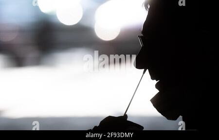 Hanovre, Allemagne. 16 avril 2021. Les aides testent un homme au 'Testzentrum am Zoo' avec un test rapide pour le nouveau virus corona. L'Institut Robert-Koch (RKI) continue de signaler une augmentation du nombre de nouvelles infections de corona en Allemagne. Credit: Julian Stratenschulte/dpa/Alay Live News Banque D'Images