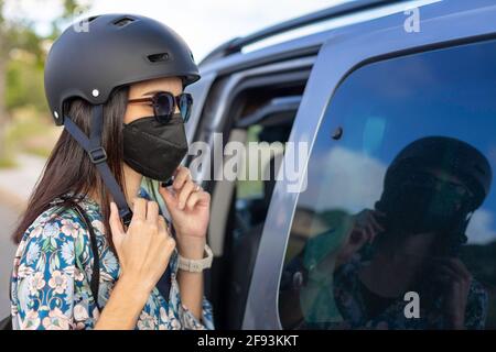 Une femme dans un masque déflamant son casque Banque D'Images