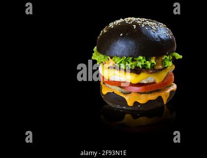 hamburger appétissant sur fond noir Banque D'Images