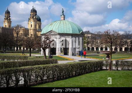 Munich, Allemagne. 16 avril 2021. Les passants se promènent au soleil à travers la Hofgarten dans le centre-ville. Au milieu de la Hofgarten, vous pouvez voir le temple Diana, à gauche, le Theatinerkirche. Credit: Sven Hoppe/dpa/Alay Live News Banque D'Images