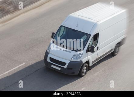 Minibus blanc va sur la ville street Banque D'Images