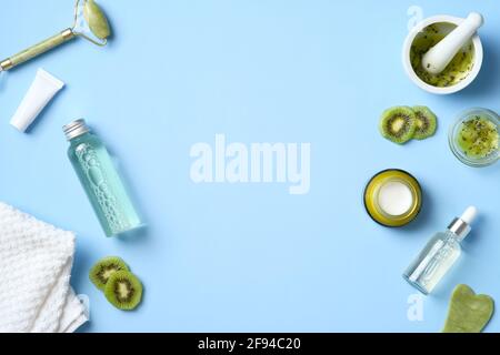 Cadre en cosmétique biologique naturelle avec kiwi sur fond bleu. Ensemble de produits de beauté à base de plantes médicinales. Flat lay, vue de dessus Banque D'Images