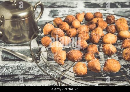 Mutzen ou Castagnole maison, beignets de carnaval typiquement allemand ou italien avec du sucre sur une grille de refroidissement Banque D'Images