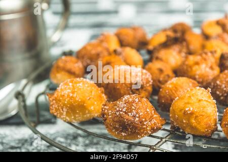 Gros plan de Mutzen ou Castagnole maison, beignets de carnaval typiquement allemand ou italien avec du sucre sur une grille de refroidissement Banque D'Images