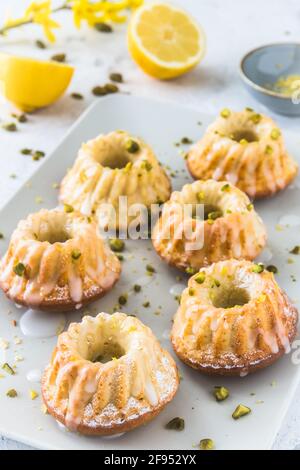 Petits gâteaux au citron faits maison (muffins) sur fond blanc, verticaux Banque D'Images