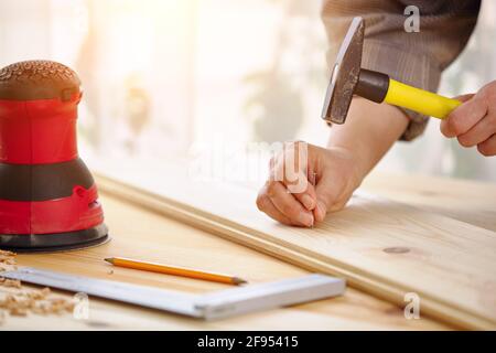 Carpenter travaille avec le bois dans l'atelier. Une femme travaille dans un atelier de menuiserie. Travaux de construction. Banque D'Images