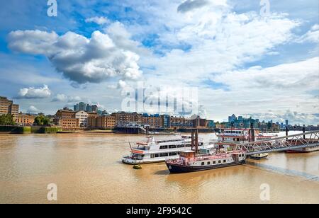 La Tamise dans l'est de Londres lors d'une journée ensoleillée avec des bateaux à passagers en face. Wappping et St. Katharine's Docks sont sur l'autre rive. Banque D'Images