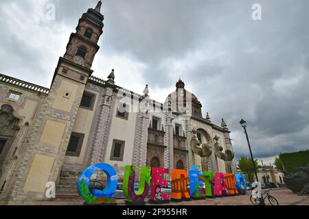 Vue extérieure panoramique sur le Baroque Santa Rosa de Viterbo avec le signe coloré de la ville à Plazuela Mariano de Las Casas, Santiago de Querétaro, Mexique. Banque D'Images