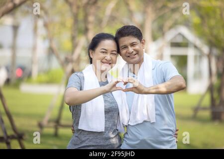 Couple senior actif faisant un cœur avec ses mains Banque D'Images