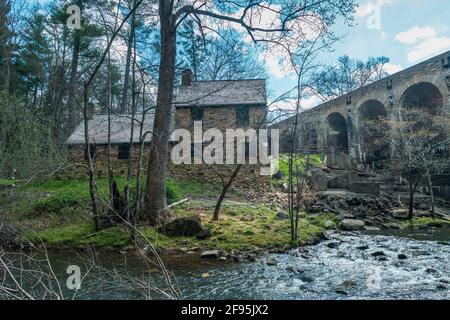 Le moulin loge derrière le pont avec le barrage le long du cours d'eau derrière le bâtiment historique en pierre dans Le parc régional de Cumberland Mountain Banque D'Images