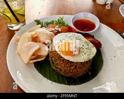 Nasi goreng (riz frit) est une cuisine traditionnelle de Bali, Indonésie. Nappé d'un œuf frit et d'échalotes séchées, mélangé avec des légumes et des craquelins aux crevettes. Banque D'Images