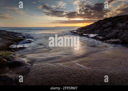 Coucher de soleil sur la plage d'Aberavon sur une marée entrante à Port Talbot, pays de Galles du Sud, Royaume-Uni Banque D'Images