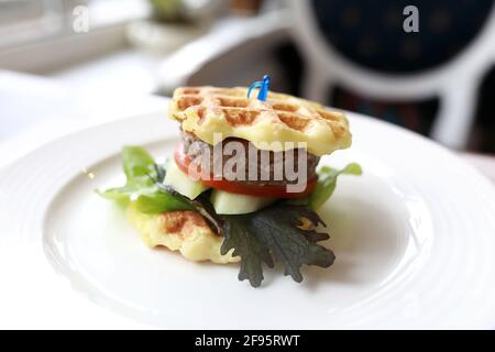 Hamburger pour enfants sur une assiette blanche dans un restaurant Banque D'Images