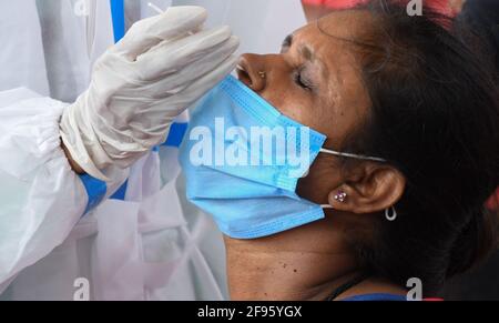 Mumbai, Inde. 16 avril 2021. Un professionnel de la santé portant un équipement de protection individuelle (EPI) prélève un échantillon d'écouvillon auprès d'un passager du Terminus de Dadar à l'arrivée à Mumbai.en raison de l'augmentation des cas de coronavirus dans l'État de Maharashtra, les passagers arrivant d'autres états doivent faire l'objet d'un bilan de santé à la gare avant de pouvoir se rendre à leur destination respective dans la ville. (Photo par Ashish Vaishnav/SOPA Images/Sipa USA) crédit: SIPA USA/Alay Live News Banque D'Images