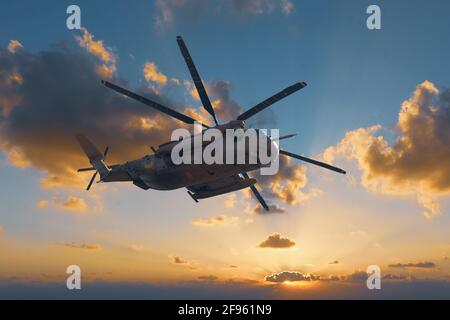 Grand hélicoptère militaire sur fond de coucher de soleil Banque D'Images