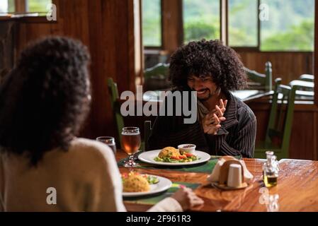 Couple assis à la table heureux de profiter de leur nourriture Banque D'Images