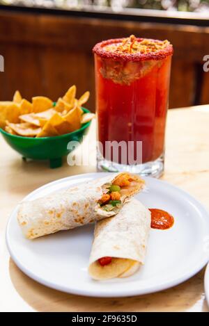 Bière mexicaine burrito et michelada avec jus de tomate et espace de copie. Banque D'Images