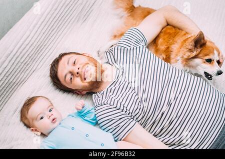 Papa et son fils sont couchés sur le lit avec le chien. Portrait en gros plan Banque D'Images