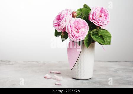 Bouquet romantique de roses dans un vase avec décoration en forme de coeur. Banque D'Images