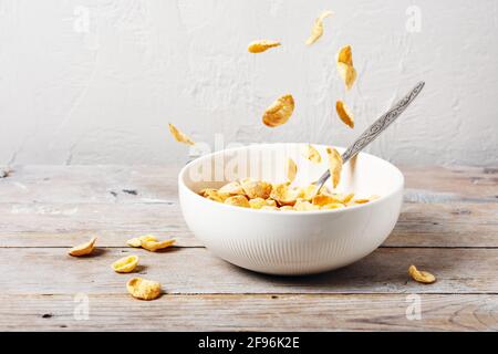 Chute de cornflakes dans un bol. Céréales avec lait. Banque D'Images