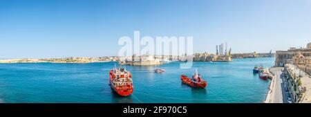 Deux navires cargo font face à la ville de Birgu avec fort St. Angelo et Senglea à la Valette, Malte Banque D'Images