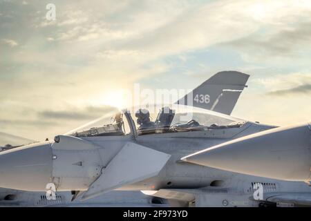 Le pilote du chasseur à réaction RAF Coningsby Lincolnshire s'est assis dans le poste de pilotage de Eurofighter Typhoon avec coucher de soleil spectaculaire derrière le ciel magnifique prêt pour décollage Banque D'Images