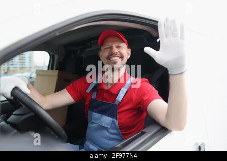 Un chauffeur de messagerie souriant dans un taxi de voiture, signe la main salutation Banque D'Images