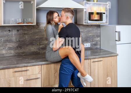 Four à micro-ondes brûlé lorsque les jeunes mariés étaient distraits par le baiser, une mauvaise utilisation de l'appareil domestique a causé un incendie à la maison. Banque D'Images