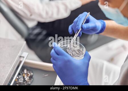 Outils dentaires et autres accessoires utilisés par les dentistes au bureau. Détail des outils dentaires à main en clinique dentaire. Dentistes avec un patient pendant un Banque D'Images